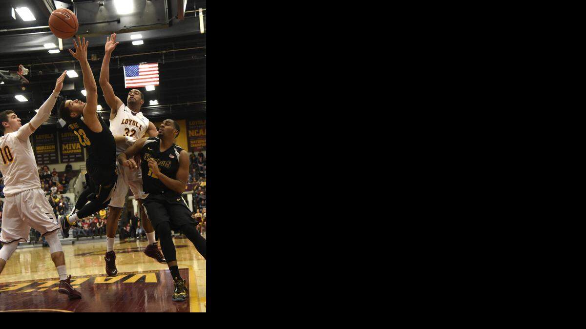 
Wichita State guard Fred VanVleet (23)shoots while he's defended by Loyola of Chicago forward Jay Knuth (10) and forward Christian Thomas (32) during the second half of an NCAA college basketball game in Chicago, Sunday, Jan. 11, 2015. Wichita State won 67-53. 
