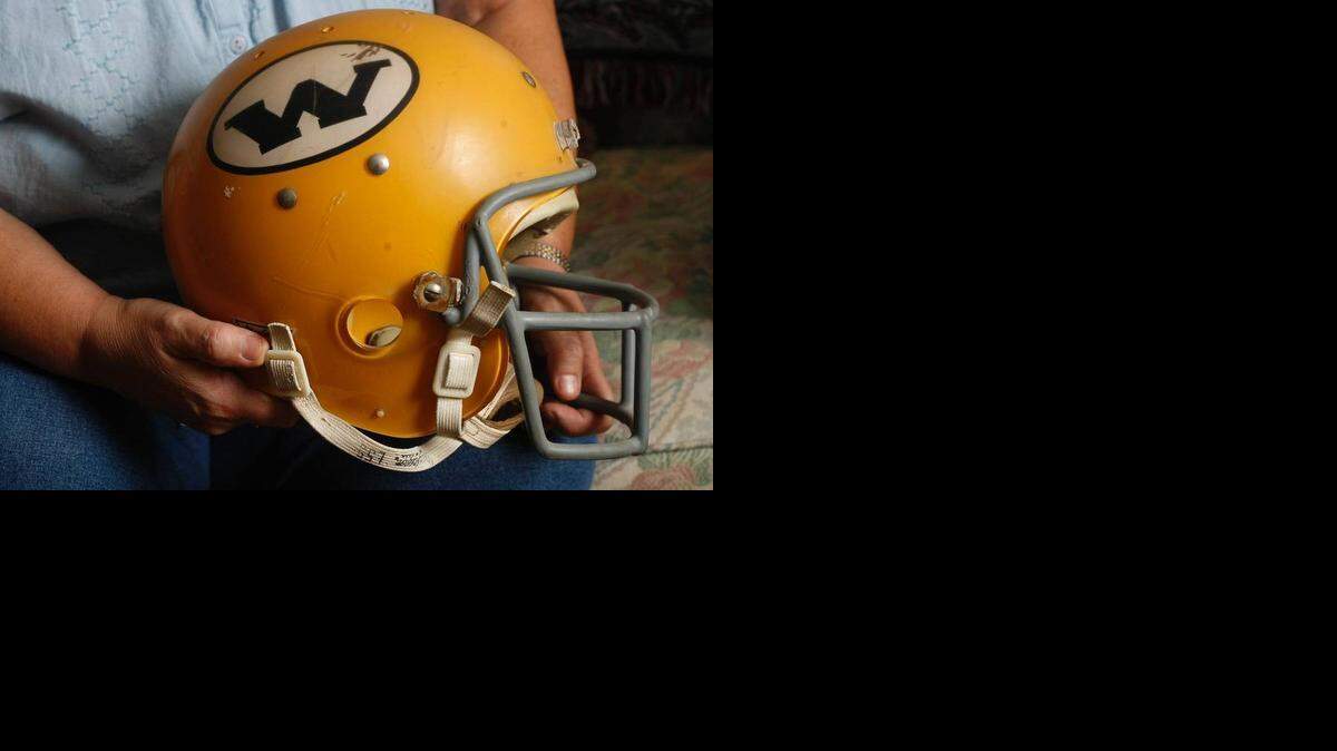
Connie Avery, of Solomon, holds the helmet her brother Marvin wore as a football player at WSU. Marvin Brown was one of 31 people killed Oct. 2, 1970, in a plane crash.
