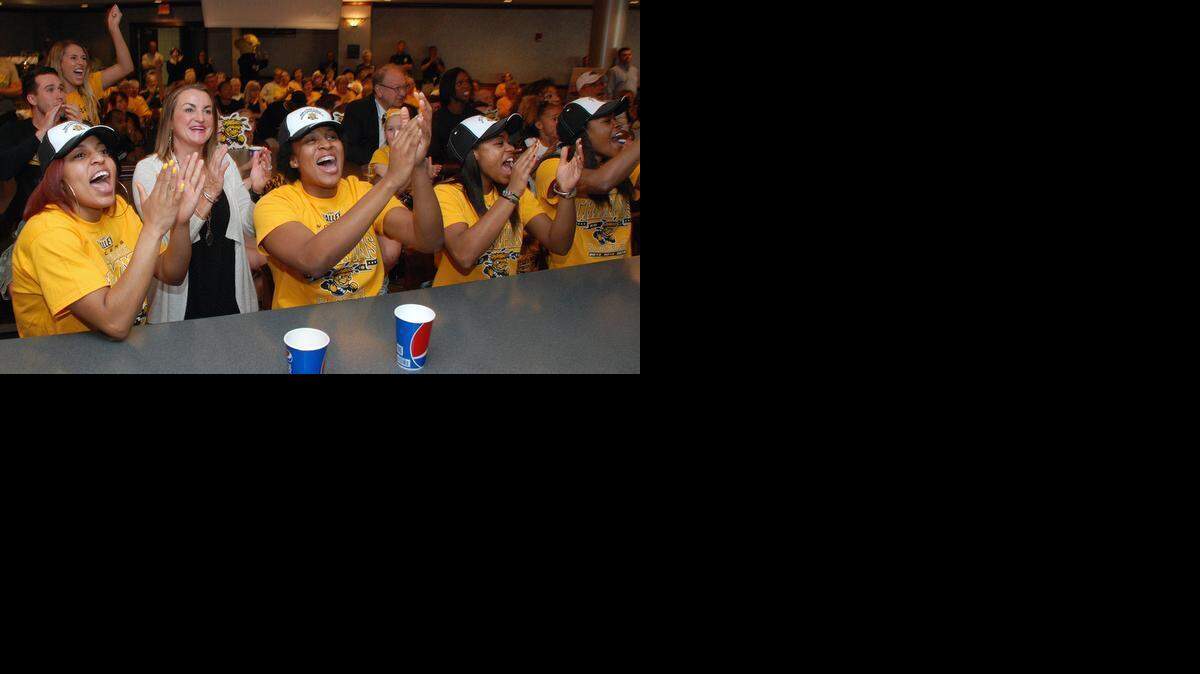 
Coach Jody Adams and her players cheer after seeing Wichita State listed during the NCAA women’s tournament selection show on Monday.
