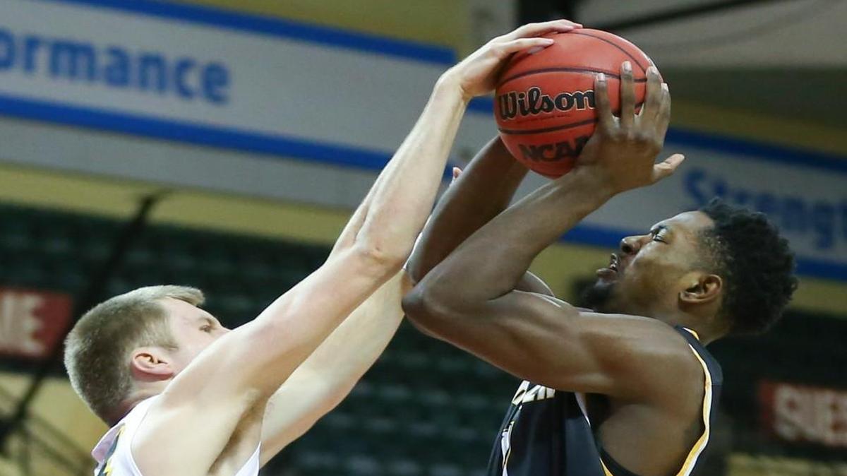 Wichita State forward Zach Brown gets tangled with Iowa guard Brady Ellingson during last Sunday’s game in Orlando, Fla.
