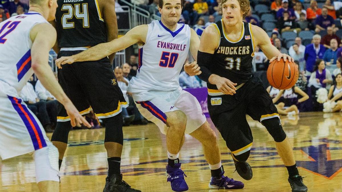 Wichita State's Ron Baker (31) drives the ball around Evansville's Blake Simmons (50) as Adam Wing (12) and Shaquille Morris (24) watch in the second half of an NCAA college basketball game Sunday, Jan. 31, 2016, in Evansville, Ind. Wichita State won, 78-65.