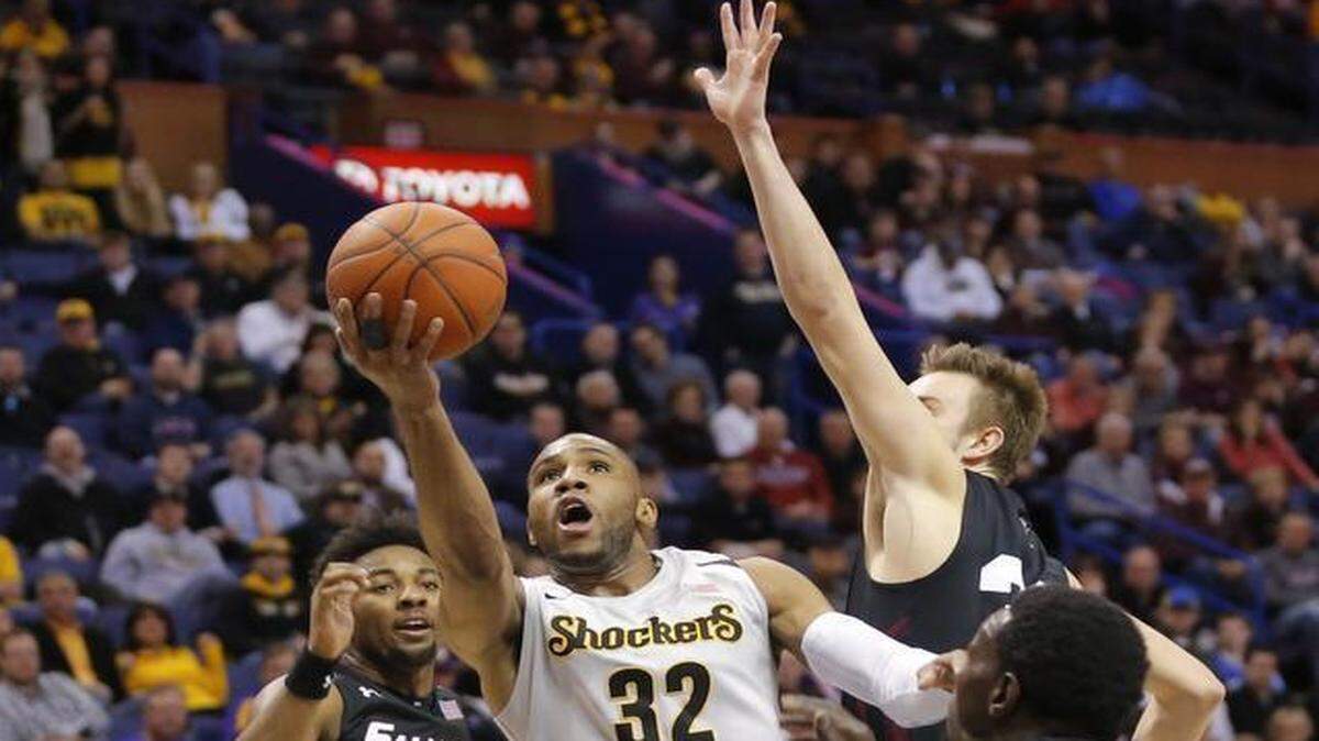 
Wichita State guard Tekele Cotton splits a group of Southern Illinois defenders during the first half of their quarterfinal game at the Scottrade Center in St. Louis on Friday.
