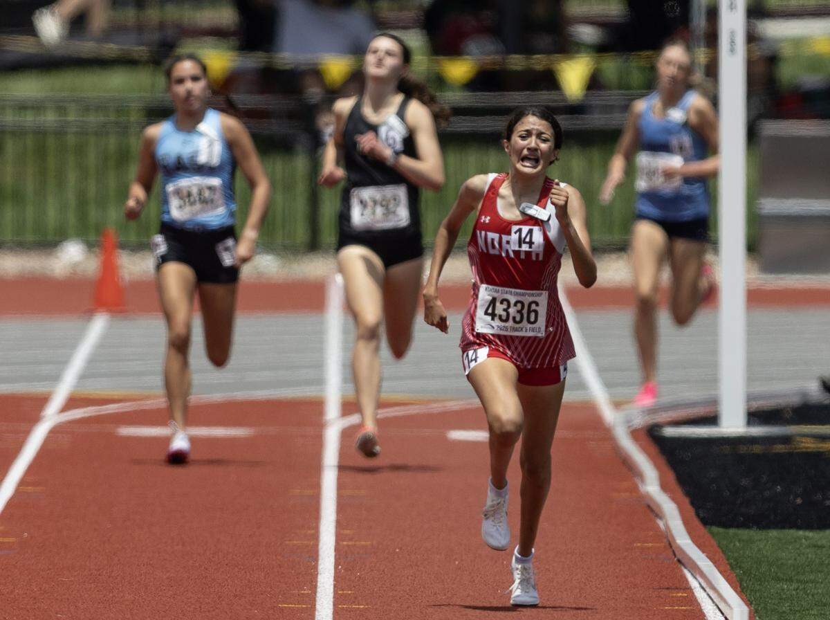Wichita North senior Nelly Puente grimaces as she digs down the final stretch of the Class 6A girls 1600-meter run, where she held off the field to win her first Kansas high school state track title Saturday at Crossland Stadium.