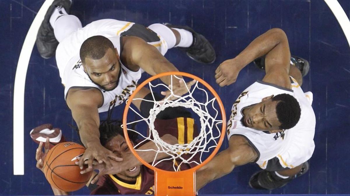 Wichita State forward Shaquille Morris, left, and Rashard Kelly defend Loyola forward Montel James during the first half.