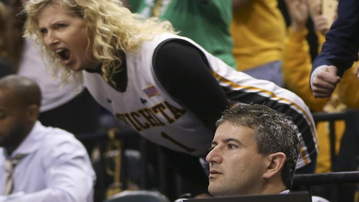 Lynn Marshall, wife of WSU coach Gregg Marshall, screams near ESPN personality Andy Katz on media row during the Shockers’ game against Dayton on Friday night in Indianapolis.