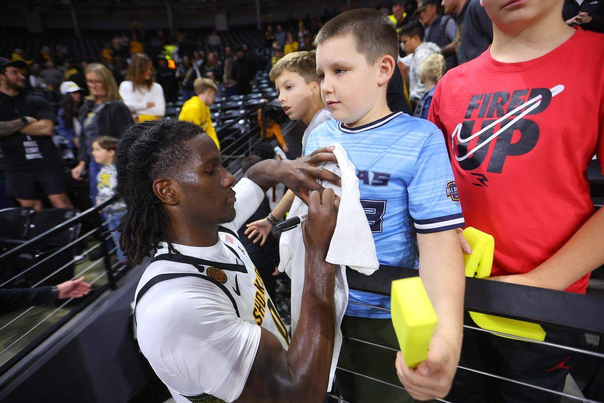 Wichita State player Karon Boyd signs an autograph for a young Shocker fan after a game earlier this season.