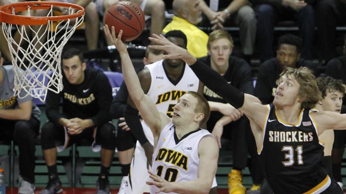 Iowa guard Mike Gesell gets past Wichita State Shockers guard Ron Baker for a basket during the first half of their game at the AdvoCare Invitational in Orlando on Sunday.