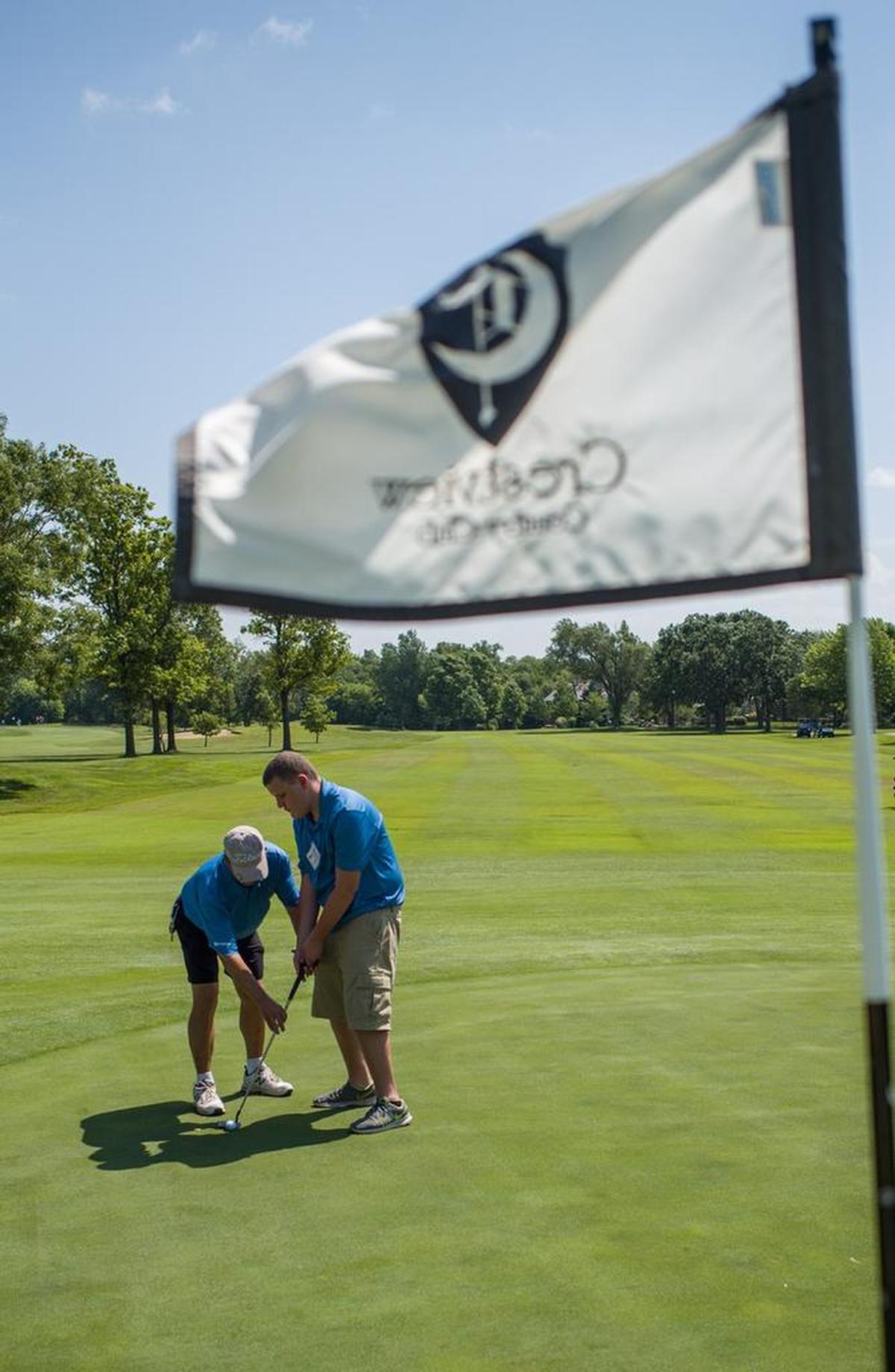 Len Hudson helps Jimmy Lewis-Swain line up a putt on the green at Crestview Country Club during the Marge Page Junior ProAm on Tuesday afternoon. Lewis-Swain was one of two vision impared golfers who participated in the Junior ProAm.