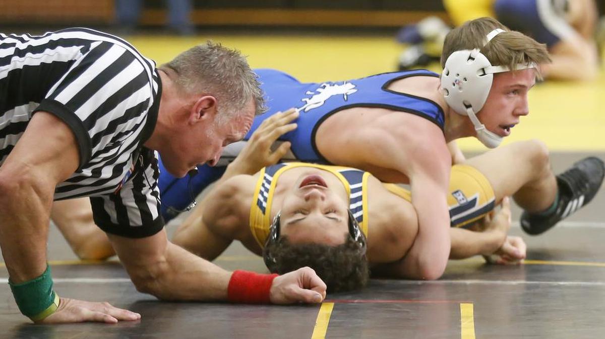 Kapaun's Adam Ayala gets ready to pin Northwest's Tray Robinson during a match last season.