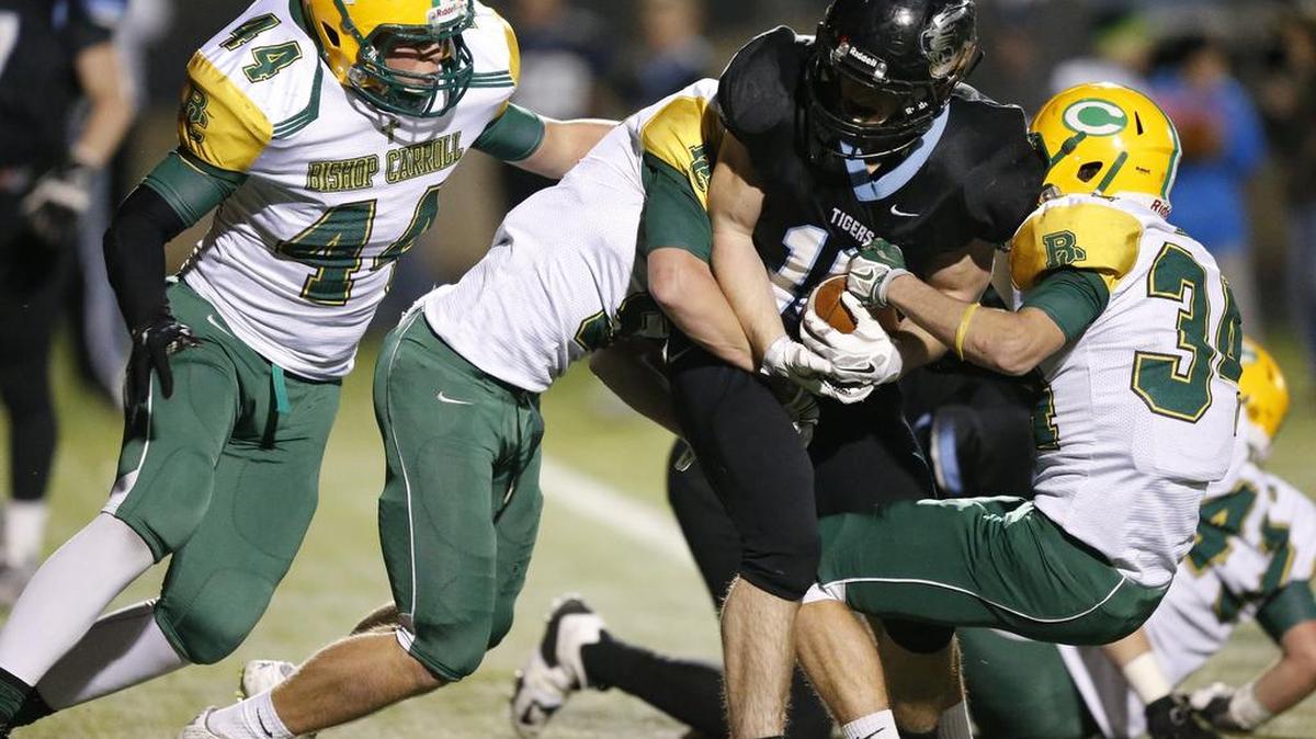 Bishop Carroll defenders stop Eisenhowers Bradon Taylor (16) on Friday night in Goddard.
