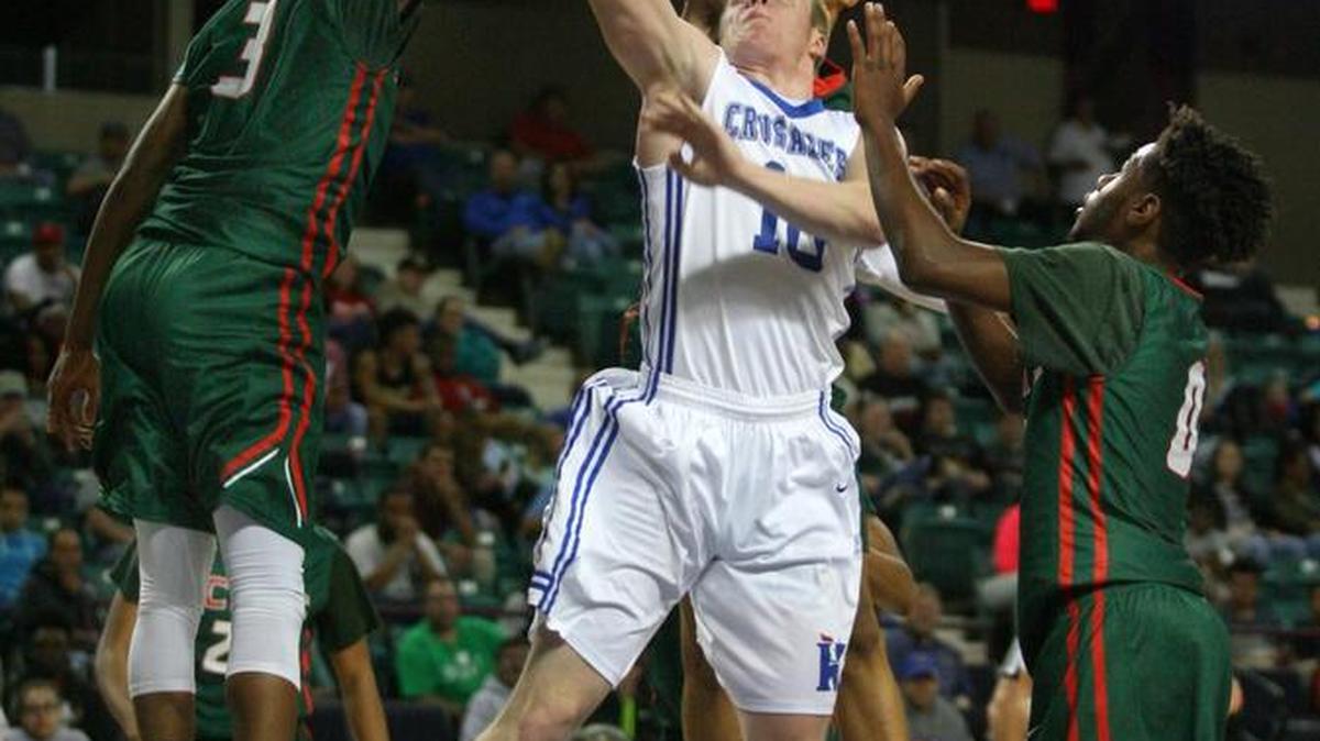 Kapaun’s Brock Monty puts up a shot against three Highland Park defenders in the first half Friday night.