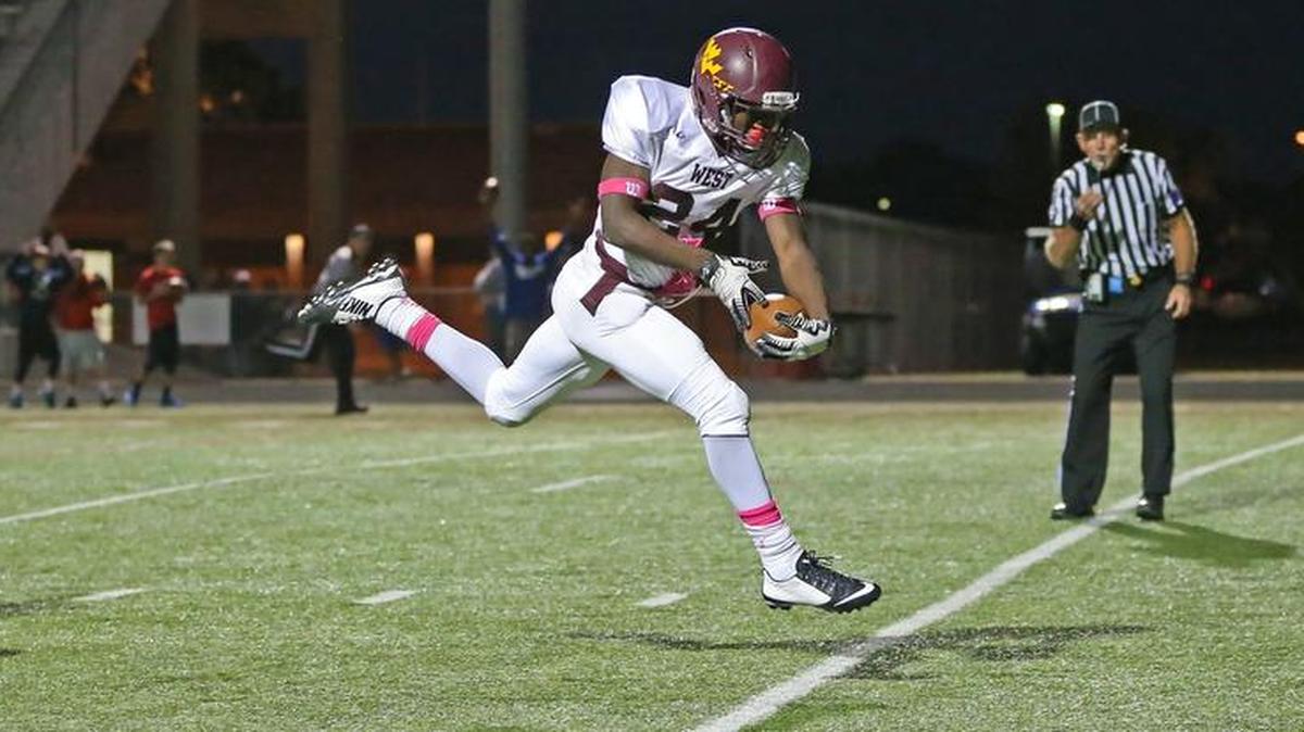 
West High’s Thomas Wasington leaves a defender behind and brings in a touchdown pass on Friday night at Wichita South High School’s Carpenter Stadium. 
