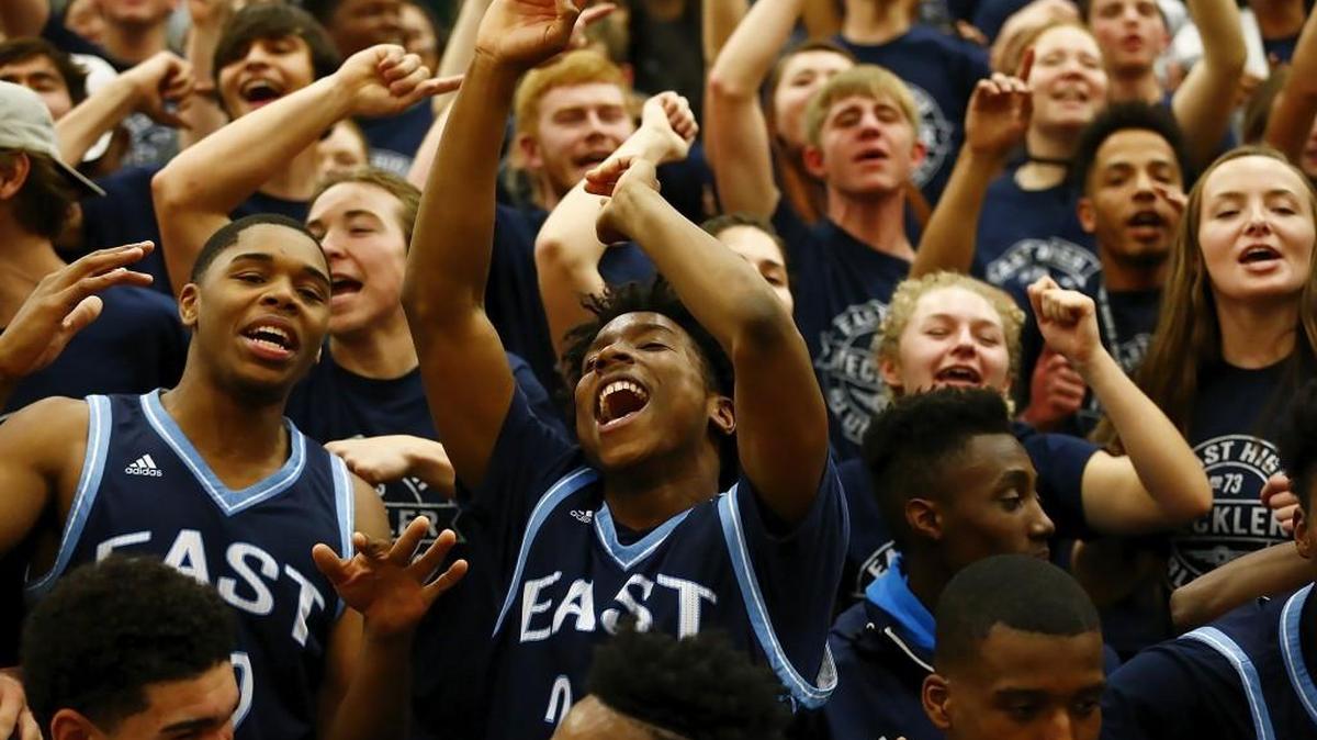 East’s D’Ron Jacobs, middle, celebrates with teammates and East students following the Aces’ 65-61 victory over Southeast on Friday night at Southeast.