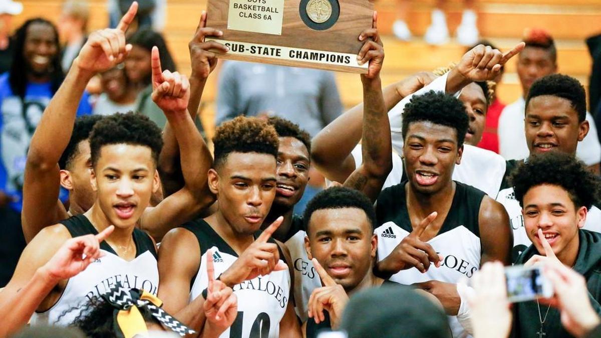 The Southeast Buffaloes hold up their sub-state trophy after defeating Lawrence Free State.