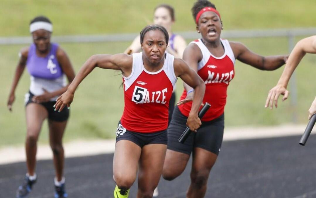 Maize's Tatiana Hopkins takes the baton from Jaraiah Johnson during the 400 relay at the 5A Goddard regional on Friday. Maize won in 50.13 seconds.