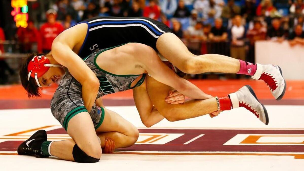 South’s Asiel Flores, left, and Derby's Cade Lindsey wrap up each other's legs of during their match in the 138 weight division at the 6A state wrestling tournament Friday at Hartman Arena.