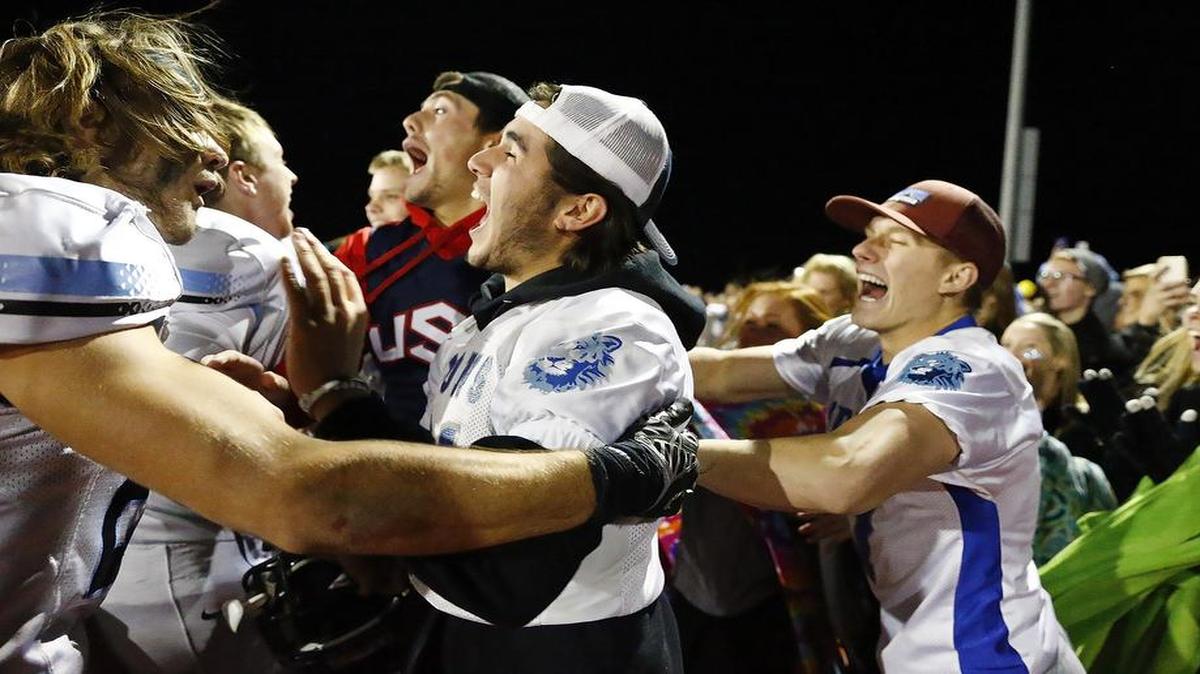 Eisenhower players and students celebrate after a football playoff game in 2015.