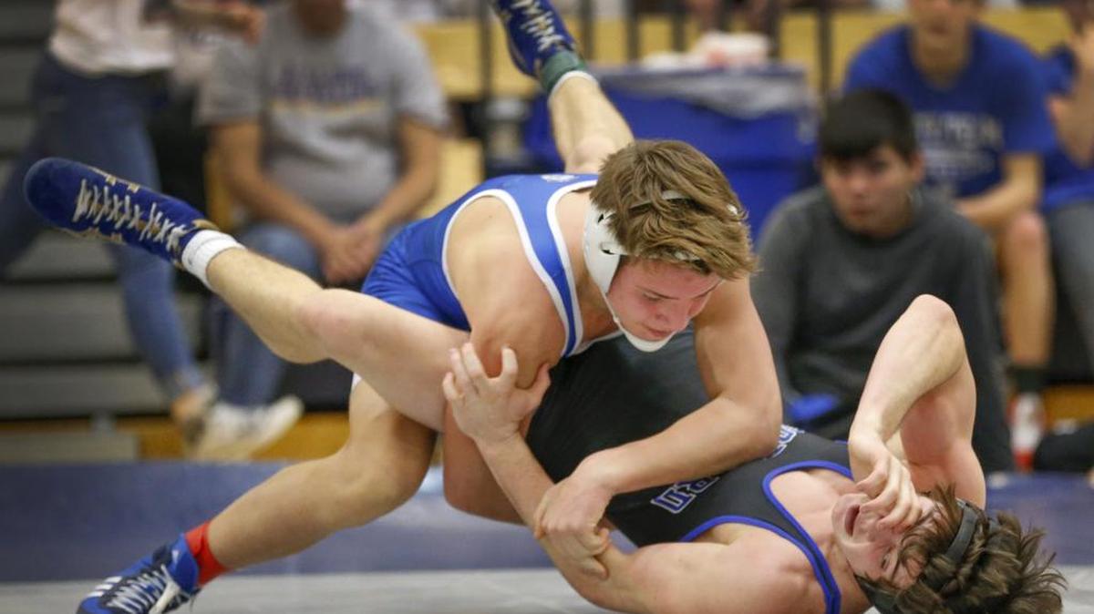 Kapaun’s Adam Ayala jumps on top of Goddard’s Christian Bowen during Ayala’s victory in the 126lb.-final at the 5A regional wrestling tournament at Andover High on Saturday.