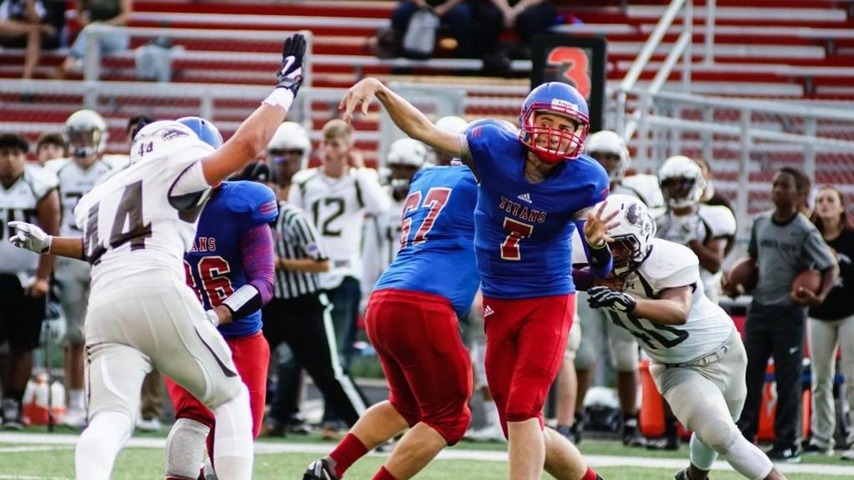 Wichita South High Titans quarterback Evan Kruse releases a pass against Garden City defender Jasper Partin in the first quarter Friday evening at South High.
