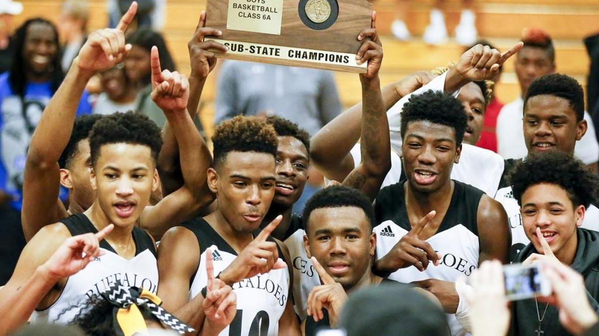The Southeast Buffaloes hold up their sub-state trophy after defeating Free State 79-77 in overtime at Southeast on Saturday.