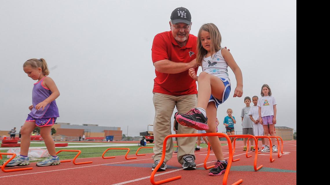 
Jayla Rodriguez gets instruction from Heights track coach Steve Crosley during a hurdle drill at the Varsity Kansas Skills Day in June 2014 at Heights High School. 
