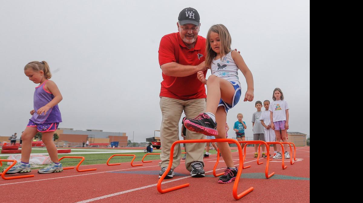
Jayla Rodriguez gets instruction from Heights track coach Steve Crosley during a hurdle drill at the Varsity Kansas Skills Day in June 2014 at Heights High School. 
