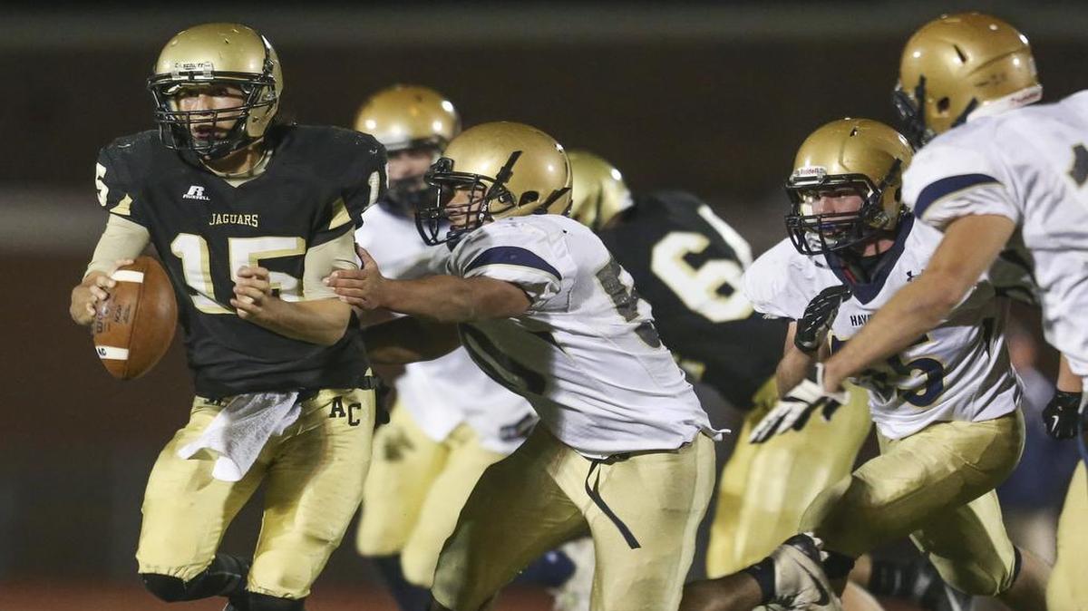 Andover Central quarterback Peyton Huslig escapes Topeka Hayden’s Jake Heit during the second quarter on Friday night at Andover District Stadium.