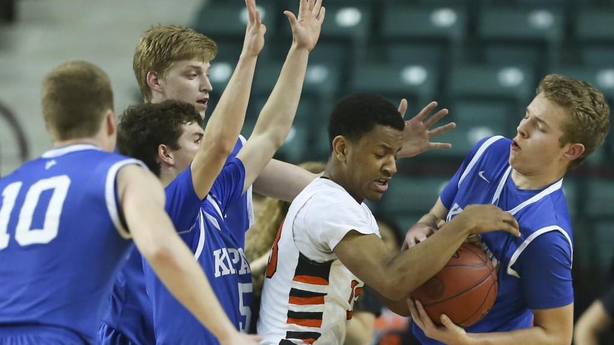 Kapaun’s Mitchell Woodward strips the ball away from Bonner Springs’ Antonio Roark during their quarterfinal game Wednesday in Topeka.