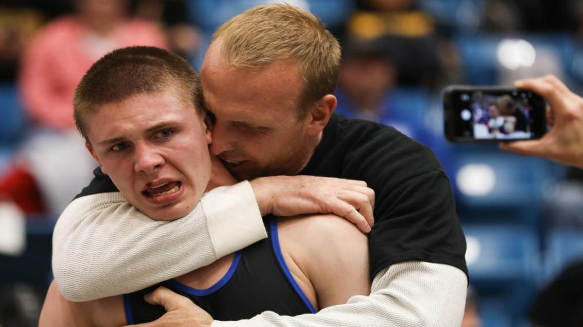 Goddard’s Garrett Lange, left, is hugged by his dad Terrence Lange after winning the Class 5A 145-pound championship on Saturday night.