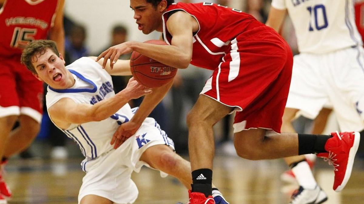 Kapaun's Thomas Wells, left, grapples for a loose ball with Heights' Devin Davis in the first half Friday night. (Dec. 2, 2016) 