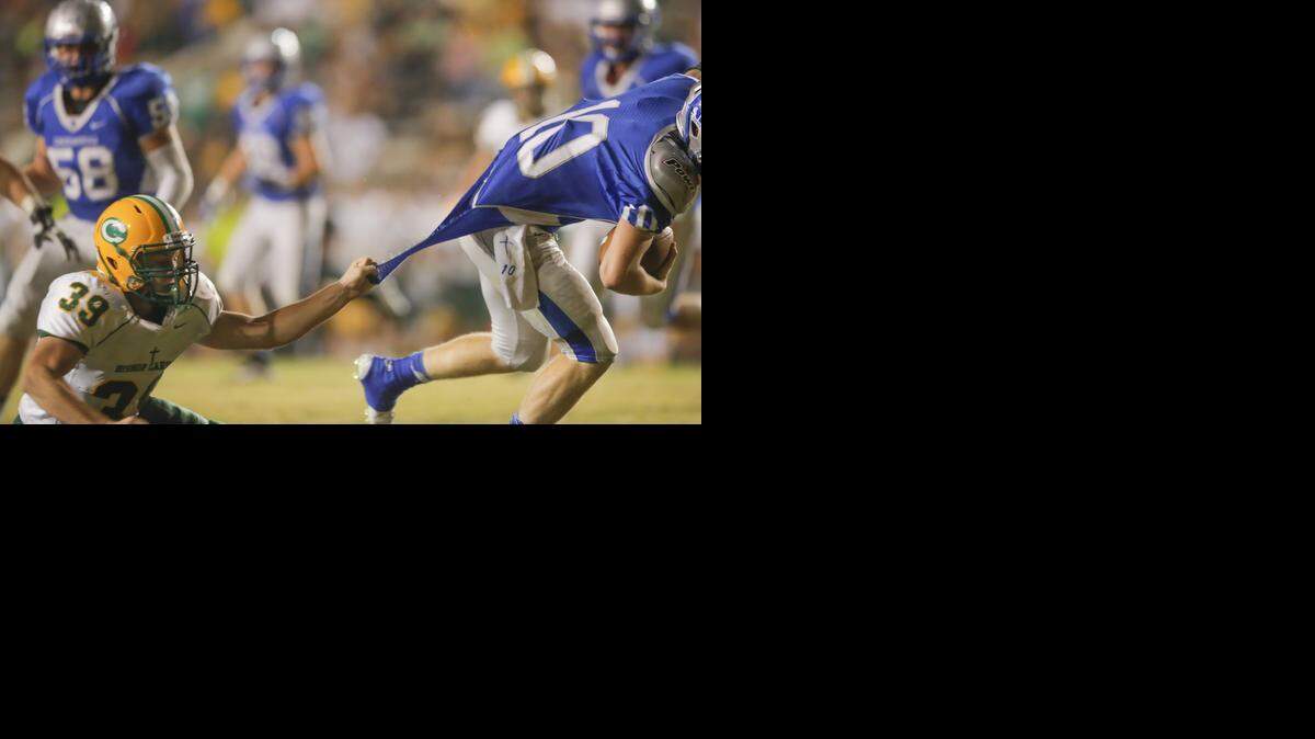 
 Carroll’s Jarrett Johnson tears the jersey of Kapaun quarterback Brock Monty. 
