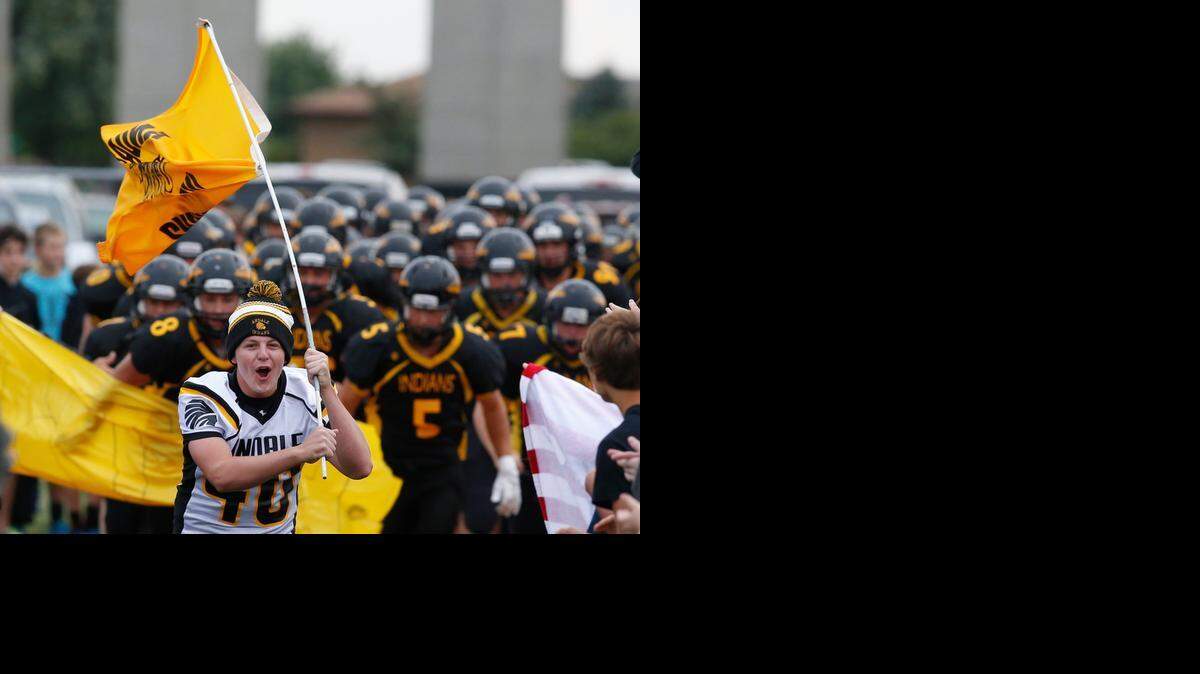 
Andale student Jordan Anderson leads the team out onto the field before the start of their game against Buhler on Sept. 5, 2014.
