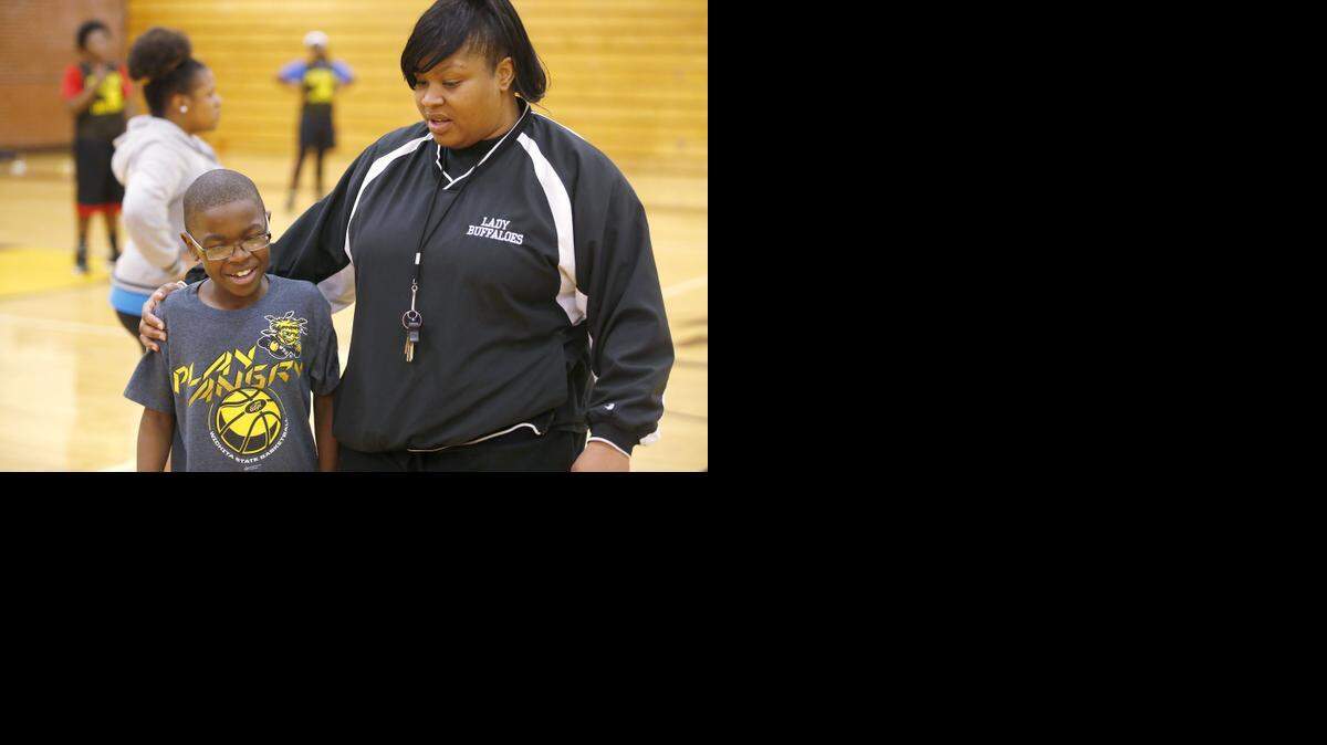 
Southeast High School basketball coach LaToya Randle talks to her son, Julian, during a recent practice. Julian has a rare autoimmune disease and cannot play basketball because of how sick he is, but he loves to be around the game and around the girls. 
