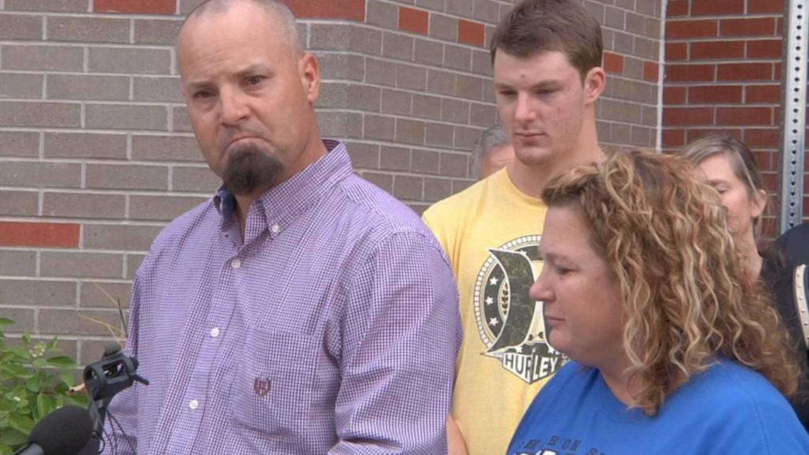 In this image taken from AP Video, David Schemm, left, makes a statement to reporters outside Swedish Hospital in Englewood, Colo., as his son, Clay, center, and wife Lisa look on during a news conference Wednesday.