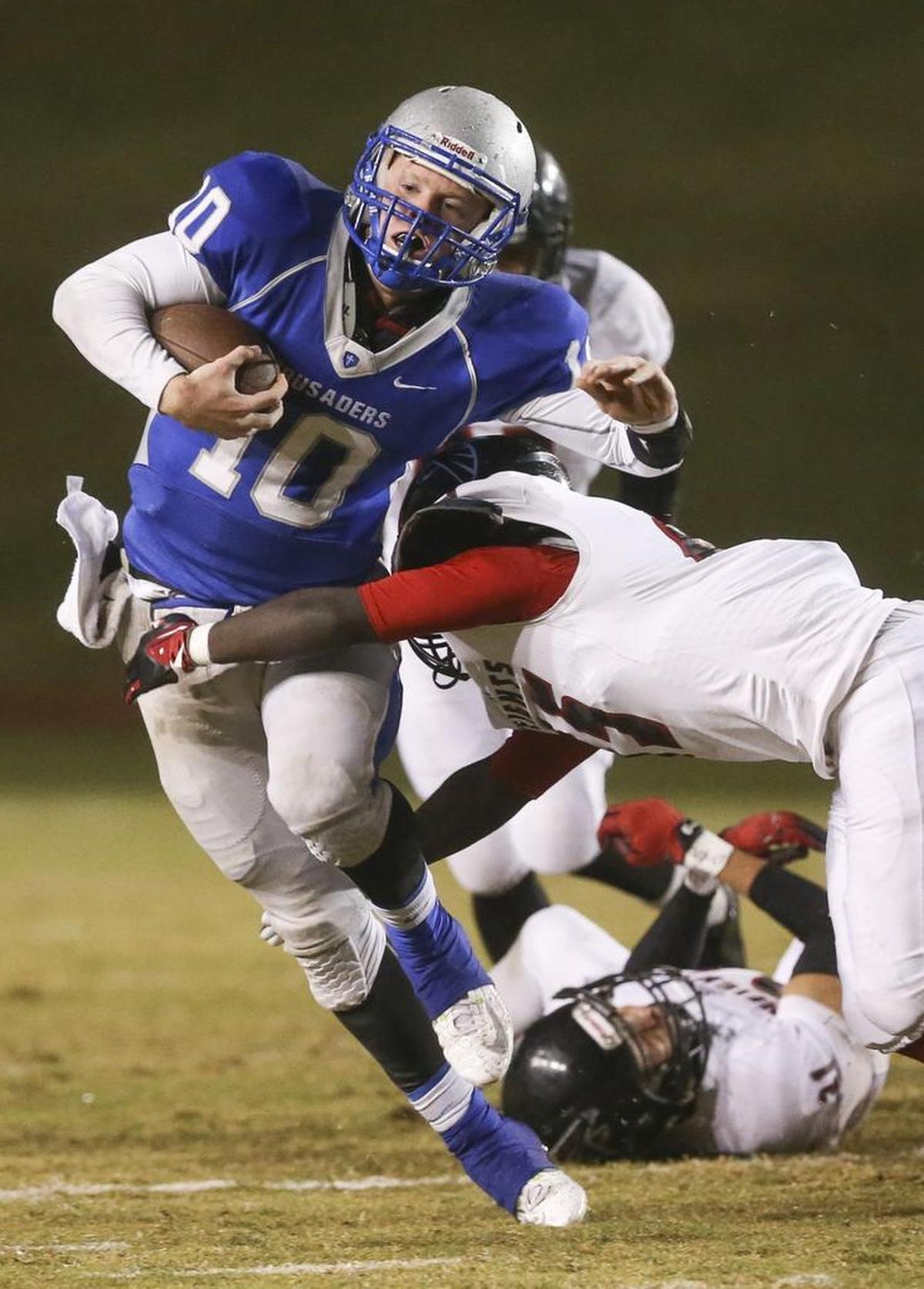 Kapaun Mt. Carmel quarterback Brock Monty is brought down during a second quarter run against Heights on Friday night at Cessna Stadium.