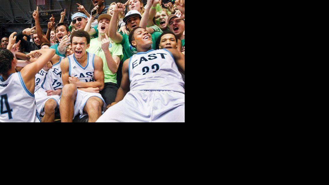 
Terence Caw, Xavier Kelly (22) and East teammates jump in the stands with the students to celebrate the Class 6A boys championship Saturday at Koch Arena. 
