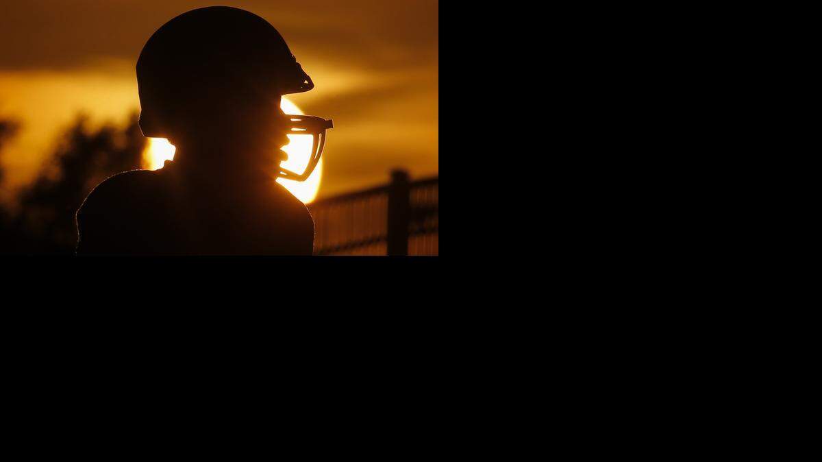 
An Andover player goes through warmups while the sun sets before their game against Kapaun Mt. Carmel on Friday night at Cessna Stadium. 
