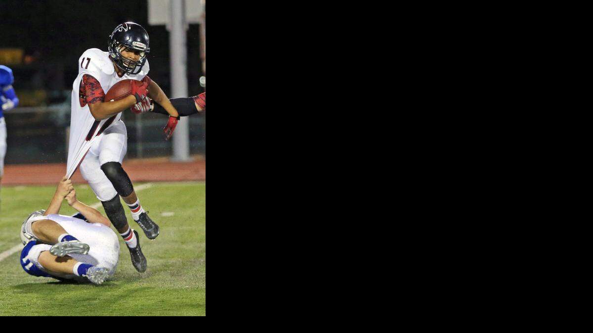 
Heights' D'Aunte McPhaul (17) can't quite escape the grasp of Coen Rasmussen (11) late in the second quarter of Friday night's game between Andover and Heights.
