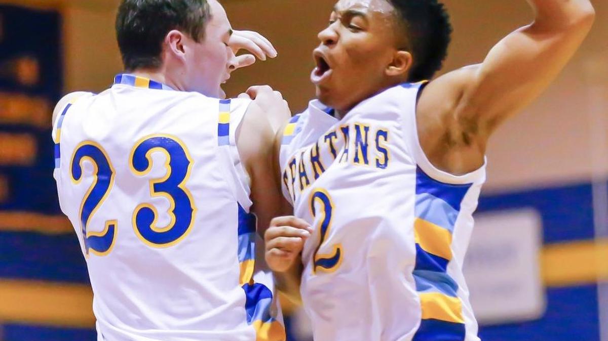 Collegiate’s Xzavier Adams (2) celebrates with teammate Nate Kelley after a big play against Andale on Feb. 23.
