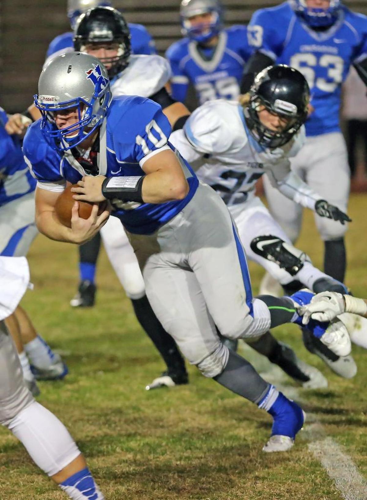 Quarterback Brock Monty of Kapaun Mt. Carmel protects the ball as he plunges forward for a first down in the first quarter of his teams matchup with Eisenhower High School.