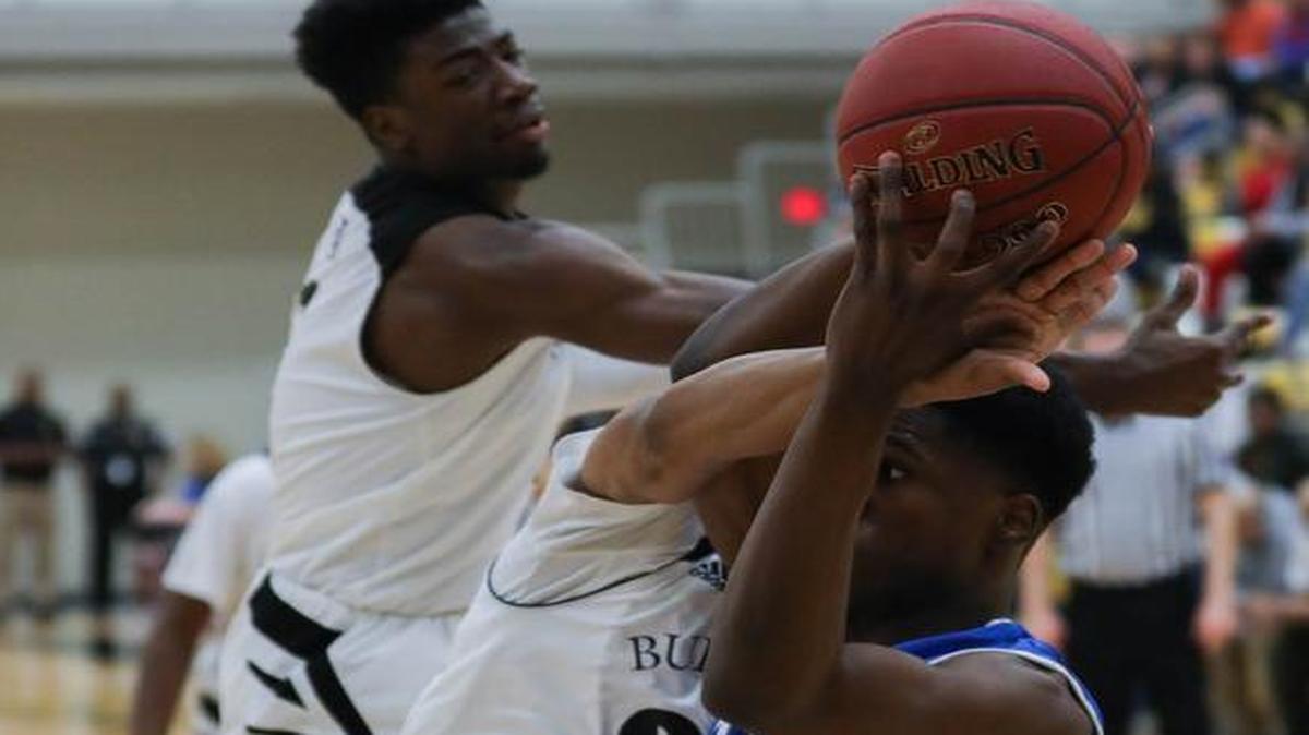 Kapaun’s Mark Hutton tries to grab a rebound while battling Southeast’s Shawn Warrior, center, and Israel Barnes on Friday night.