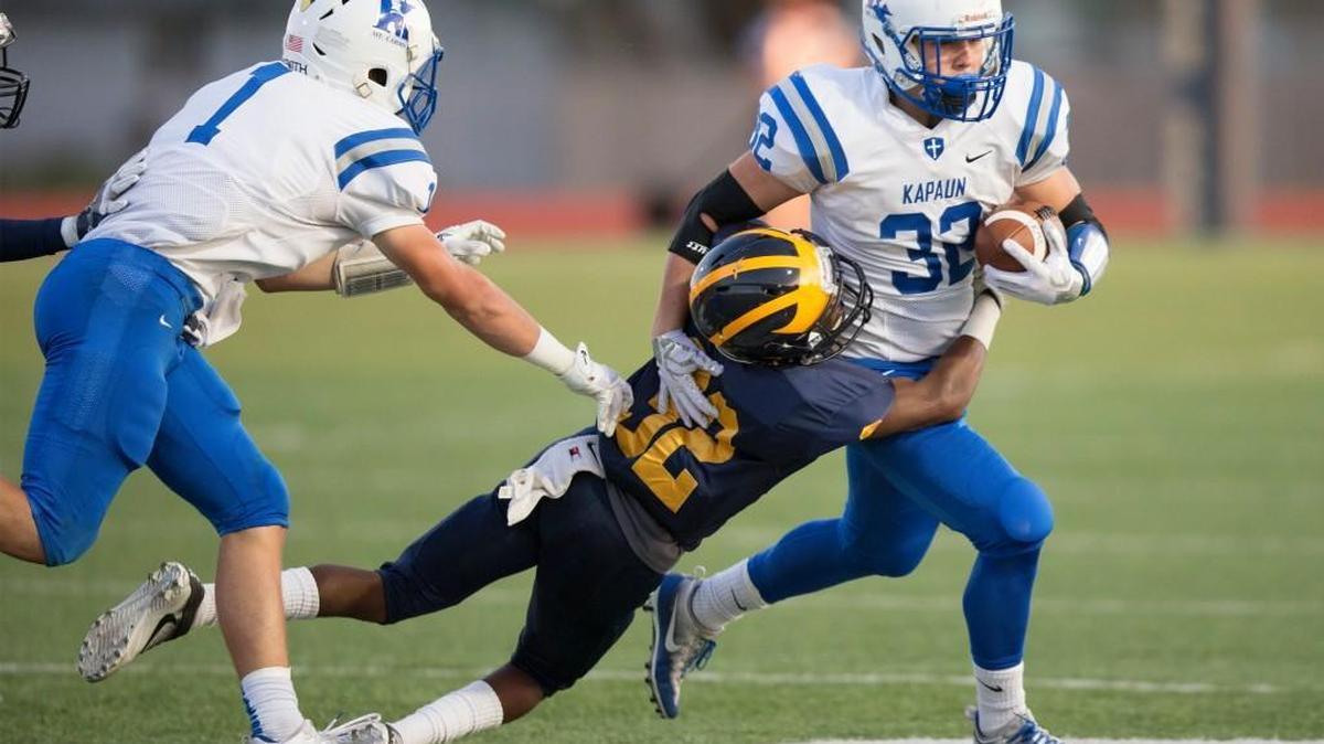 Kapaun's Tate Heiland (32) is tackled by a Northwest defender last Friday.