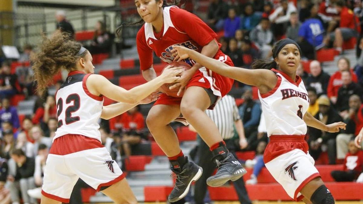 South’s Loan-Anh Johnson, center, gets tied up by Heights’ Whitlee Teague, left, and Taylor Jameson in the fourth quarter Tuesday at Heights. Four-time defending 6A champion South beat Heights 55-39 and remained unbeaten.