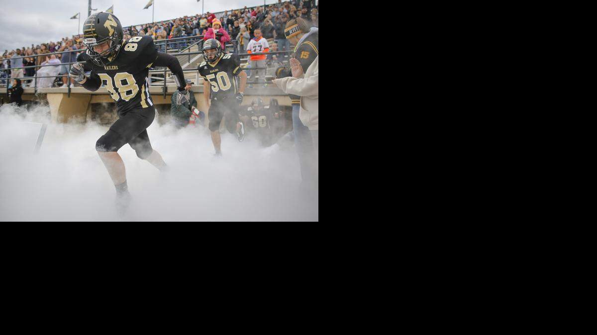 
Newton players Trevor Pryor and Cameron Galloway take the field through fog created by fire extinguishers before their game against Huthcinson in Week 2.
