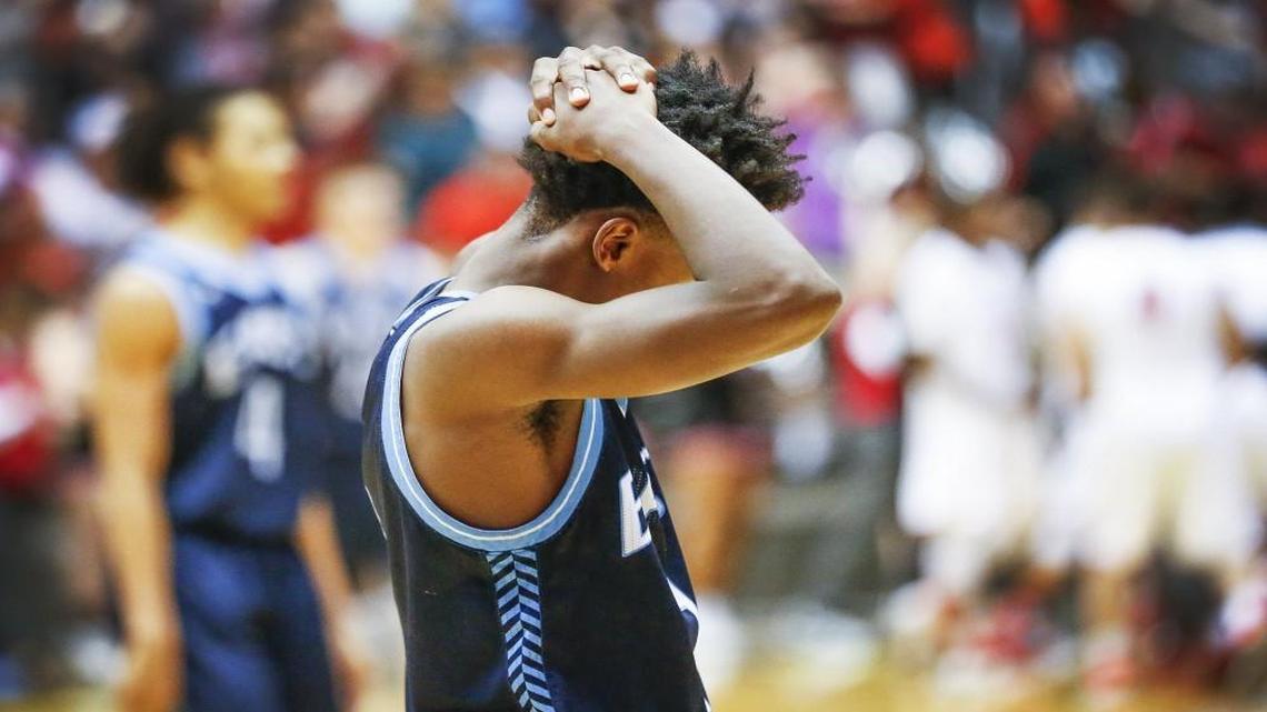 East's Michael McKinney holds his head as the Aces’ comeback comes up short as they lose to Shawnee Mission North 55-52 Thursday at the Class 6A tournament at Koch Arena.
