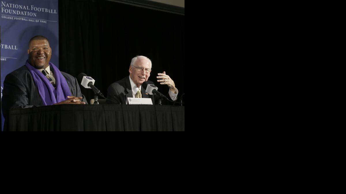 
Former Washington offensive tackle Lincoln Kennedy, left, laughs as Kansas State head football coach Bill Snyder explains to his wife offstage how he got the number of children they have together wrong during a news conference announcing the 2015 College Football Hall of Fame Class, Friday, Jan. 9, 2015, in Dallas. 
