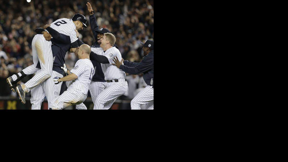 
New York Yankees’ Derek Jeter (2) is mobbed by teammates after driving in the winning run with a single against the Baltimore Orioles in the ninth inning of a baseball game, Thursday, Sept. 25, 2014, in New York. The Yankees won 6-5. (AP Photo/Julie Jacobson) 
