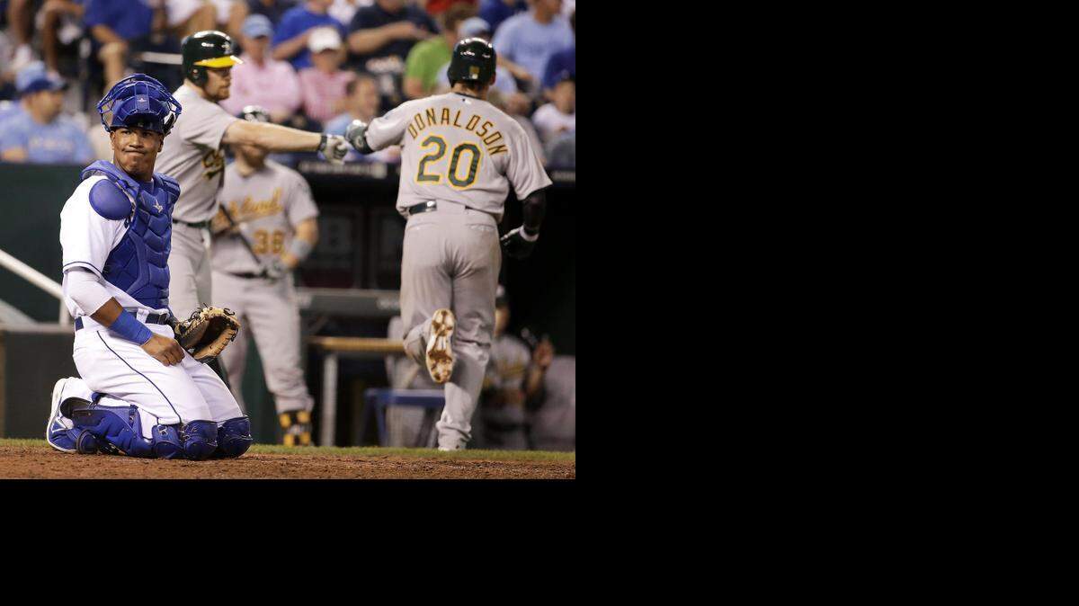 
Royals catcher Salvador Perez reacts after Oakland Athletics' Josh Donaldson (20) hit a solo home run during the seventh inning of a baseball game Tuesday, Aug. 12, 2014, in Kansas City, Mo. (AP Photo/Charlie Riedel)
