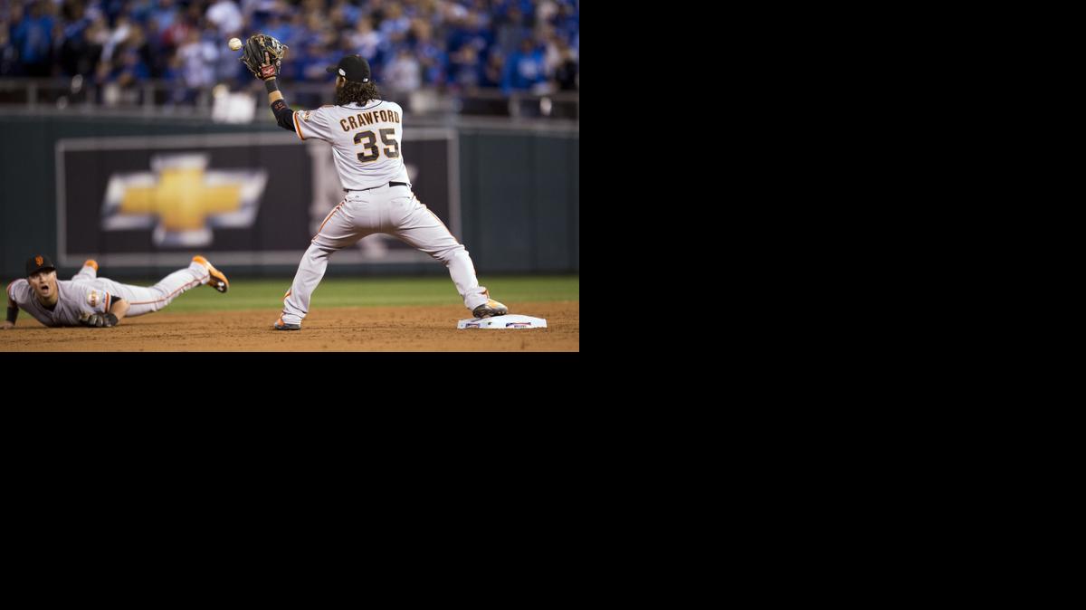 
San Francisco second baseman Joe Panik, left, throws to shortstop Brandon Crawford (35) to start a double play against Kansas City in the third inning during Game 7 of the World Series on Wednesday in Kansas City, Mo.
