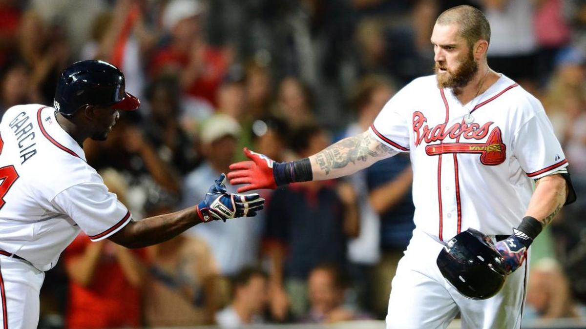 
Atlanta’s Jonny Gomes, right, is greeted by teammate Adonis Garcia after hitting a home run against Colorado on Aug. 26.
